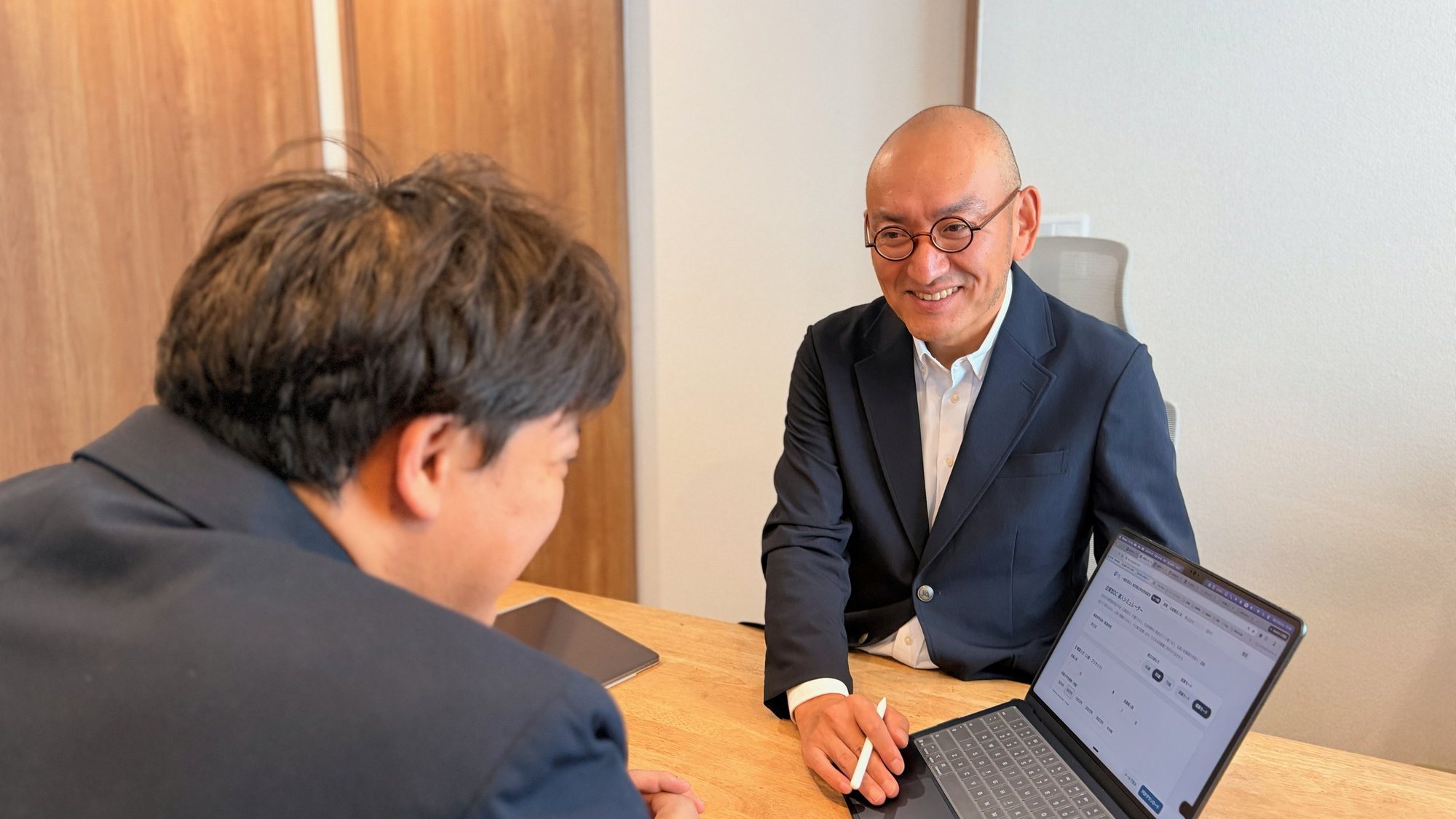 面談で、笑いながら画面を見せて説明しているところ